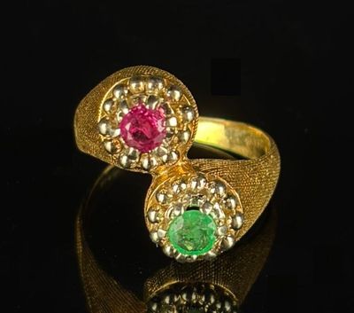 a close up of two rings with different colored stones on a black surface