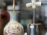 un vase posé sur une table, sur laquelle se trouve une lampe