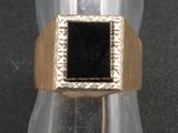 une image représentant une bague en or sertie d'une pierre noire