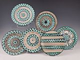un ensemble de quatre assiettes décorées, posées sur une table