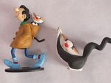deux figurines représentant un homme et un chien sur un skateboard