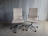 une paire de fauteuils de bureau en cuir blanc devant un mur en tôle ondulée