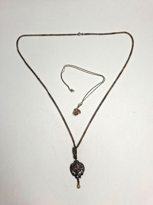 un gros plan d'un collier et d'une boucle d'oreille posés sur une surface blanche