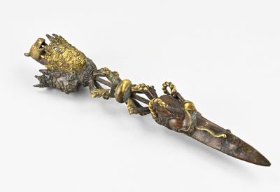 un petit objet métallique surmonté d'un oiseau