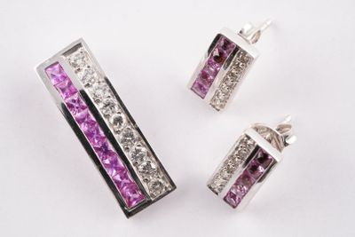 trois bijoux en cristal violet et blanc posés sur une surface blanche