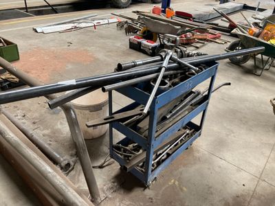 a blue work cart with tools on it in a garage
