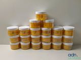 plusieurs pots de moutarde alignés les uns à côté des autres sur une table