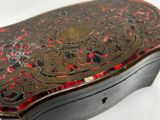 an old wooden box with a red and black design on it