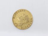 a close up of a gold coin on a white surface