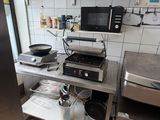 a kitchen with a stove, microwave, and other appliances in it