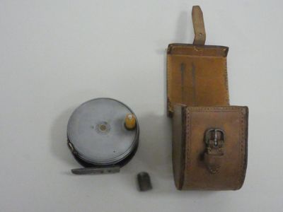 a leather case with a knife and other items on the table