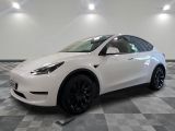 La Tesla Model Y blanche est garée dans une grande pièce.