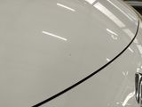 a close up of a white car with a black stripe on it
