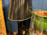une table sur laquelle se trouvent une lampe et un verre à vin