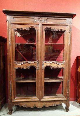 un meuble en bois avec des portes en verre dans une pièce