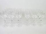 Plusieurs verres à vin transparents sont alignés sur une surface blanche