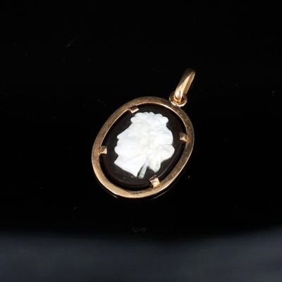 un pendentif en or orné d'un camée représentant une femme de profil