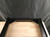 un gros plan d'une table avec un plateau en bois et un piètement en métal