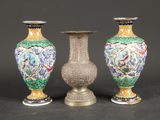 trois vases sont posés sur une table devant un fond noir