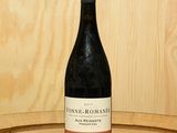 une bouteille de vin posée sur un tonneau en bois