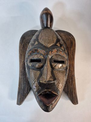AFRIQUE Masque en bois sculpté, laiton et perles.