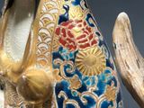 a figurine of a cat with a bird on it ' s back
