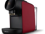 une cafetière rouge et noire à côté d'un verre d'eau