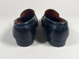 a pair of black leather shoes on a white surface