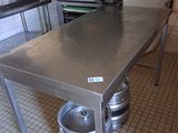 a stainless steel table with kegs on it in a kitchen