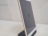 a tablet computer sitting on a stand on a white surface