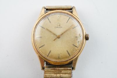a gold watch on a white surface with a white background