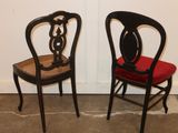 two black chairs with red cushions on them in a room