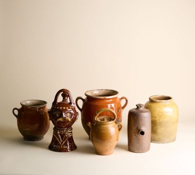cinq vases différents posés sur une table, sur fond blanc