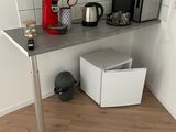une petite cuisine avec un micro-ondes, un grille-pain, un grille-pain et une cafetière posés sur le plan de travail