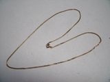 a close up of a gold chain on a white surface