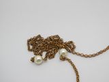un gros plan d'un collier composé de perles montées sur une chaîne