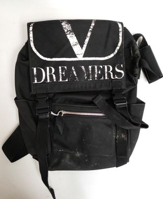 Le sac à dos est noir et comporte un « V » blanc.