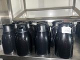 de nombreux vases noirs posés sur une étagère dans une cuisine