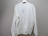 the white sweatshirt is hanging on a hanger on the wall