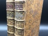 deux vieux livres posés l'un sur l'autre sur une table