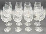 six clear wine glasses are lined up on a table