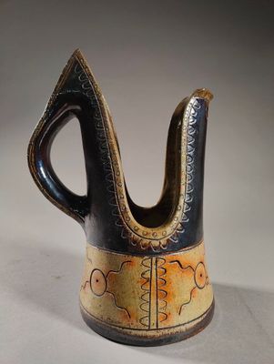 a black and brown vase with a design on it