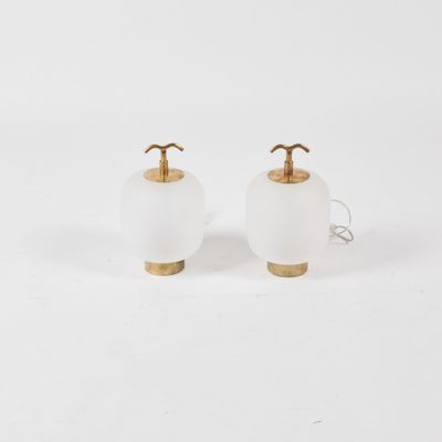 a pair of white glass lamps with brass fittings