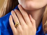 Cette femme porte une chemise bleue et une bague en or.