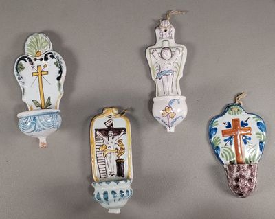 quatre horloges murales en céramique accrochées en rangée sur un mur