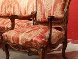 a couch and two chairs in a room with red walls