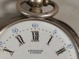 a close up of a pocket watch with roman numerals