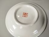 a white plate with a red stamp on it