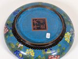 a blue bowl with flowers on it on a white surface