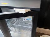 a small refrigerator with a glass door in a room